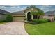 Charming single-story home featuring a well-manicured lawn, brick driveway, and an attached two-car garage at 6408 Christina Chase Pl, Lakeland, FL 33813