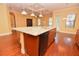 The kitchen shows a large island with granite countertops, a black dishwasher, a sink, and natural-wood cabinets at 6408 Christina Chase Pl, Lakeland, FL 33813