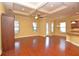 Open living space with tray ceiling, wood floors, many windows, and a pass-through to the kitchen at 6408 Christina Chase Pl, Lakeland, FL 33813