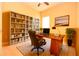 Bright office featuring hardwood floors, built-in bookshelves, and a stylish desk with a comfortable leather chair at 6408 Christina Chase Pl, Lakeland, FL 33813
