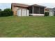A home featuring a screened porch, a tool shed, and a well-maintained grassy backyard at 7923 Glenridge E Loop, Lakeland, FL 33809
