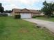 Single-story house showing a well-kept lawn and a wide driveway leading to a two-car garage at 7923 Glenridge E Loop, Lakeland, FL 33809
