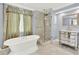 Luxurious bathroom featuring a standalone tub, glass shower, and an elegant mirrored vanity at 351 Crystal Ridge Way, Lake Mary, FL 32746