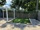 Backyard putting green with white pergola, stone paver surround and wood fence at 508 Garden N Dr, Lakeland, FL 33813