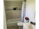 Tiled bathtub and shower area with a white patterned shower curtain and neutral-toned walls at 105 Byron Pl, Winter Haven, FL 33884