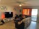 Living room featuring a fan, hardwood floors, and access to the backyard at 105 Byron Pl, Winter Haven, FL 33884