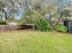 Lush backyard with a well-maintained lawn, mature trees, and a privacy fence at 3320 Mango Tree Dr, Edgewater, FL 32141