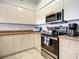 Well-equipped kitchen featuring stainless steel appliances and white cabinetry at 5300 S Atlantic Ave # 6-505, New Smyrna Beach, FL 32169