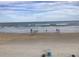 Relaxing beach scene with people enjoying the ocean at 4811 Saxon # A201, New Smyrna Beach, FL 32169