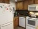 Efficient kitchen with white appliances and wood cabinets at 4811 Saxon # A201, New Smyrna Beach, FL 32169