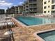 Community pool and spa with surrounding lounge chairs at 4811 Saxon # A201, New Smyrna Beach, FL 32169
