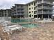 Community pool and spa with lounge chairs at 4811 Saxon # A201, New Smyrna Beach, FL 32169