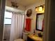A well-lit bathroom featuring a shower, vanity, and a decorative mirror above the sink at 1470 Ne Old Mill Dr, Deltona, FL 32725