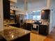 Modern kitchen featuring stainless steel appliances, granite countertops, and dark wood cabinets at 1470 Ne Old Mill Dr, Deltona, FL 32725