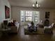 Cozy living room with bay window, neutral furniture, stylish decor, and ample natural light at 1470 Ne Old Mill Dr, Deltona, FL 32725