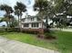 Two-story house with brick and white siding, surrounded by palm trees and lush lawn at 214 S Riverside Dr, New Smyrna Beach, FL 32168