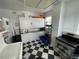 Kitchen features white cabinets, black and white checkered floor and stainless steel appliances at 214 S Riverside Dr, New Smyrna Beach, FL 32168