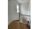 Upstairs hallway with hardwood floors and white railings at 214 S Riverside Dr, New Smyrna Beach, FL 32168
