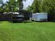Backyard featuring a boat and trailer, and a screened in pool area, all surrounded by lush green grass at 806 South St, New Smyrna Beach, Fl 32168, FL 32168