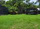 Spacious backyard featuring lush green grass, a screened in pool area, and a boat in the distance at 806 South St, New Smyrna Beach, Fl 32168, FL 32168