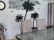 Tropical themed outdoor living space with black palm tree mural and neutral patio furniture at 806 South St, New Smyrna Beach, Fl 32168, FL 32168