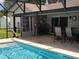 Screened pool area with outdoor seating, a beige patio, and access to the home's interior at 806 South St, New Smyrna Beach, Fl 32168, FL 32168