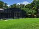 Lush backyard with screened-in pool, offering a private and serene outdoor oasis at 806 South St, New Smyrna Beach, Fl 32168, FL 32168