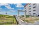 Boardwalk to Oyster Quay beach access point next to a building and clear blue skies at 4303 Sea Mist Dr # 225, New Smyrna Beach, FL 32169