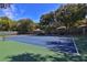 Community tennis court featuring a green and blue surface, net, and surrounded by a tall dark fence at 4303 Sea Mist Dr # 225, New Smyrna Beach, FL 32169