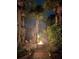 Nighttime view of outdoor fire pit with flames, surrounded by tropical landscaping and lighting at 4606 Doris Dr, New Smyrna Beach, FL 32169