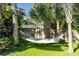 Backyard with a comfortable hammock strung between palm trees, offering relaxation in a lush setting at 4606 Doris Dr, New Smyrna Beach, FL 32169
