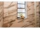 Stylish shower showcasing marble-style tiles with a creative decorative shell and a growing plant in the window at 4606 Doris Dr, New Smyrna Beach, FL 32169
