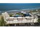 Breathtaking aerial view of the condo complex with its pool, lush landscaping, and direct beach access at 3663 S Atlantic Ave # 21C, New Smyrna Beach, FL 32169