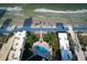 Aerial view from above the ocean of a condo complex, showing the pool and lounge area between it and the beach at 3663 S Atlantic Ave # 21C, New Smyrna Beach, FL 32169