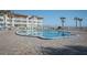 Inviting community pool surrounded by lounge chairs, palm trees, and beach views, perfect for relaxation and enjoyment at 3663 S Atlantic Ave # 21C, New Smyrna Beach, FL 32169