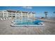 Sparkling community pool near the beach with palm trees, lounge chairs, and condo views, perfect for summer relaxation at 3663 S Atlantic Ave # 21C, New Smyrna Beach, FL 32169
