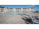 Community pool with beachfront condo building in background, lounge chairs, and palm trees for outdoor relaxation at 3663 S Atlantic Ave # 21C, New Smyrna Beach, FL 32169