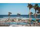 Relaxing pool area with ocean views, palm trees, lounge chairs and beach access at 3663 S Atlantic Ave # 21C, New Smyrna Beach, FL 32169