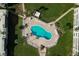 Aerial close up of a kidney-shaped community pool with lounge chairs on the deck and landscaping around the fenced perimeter at 3663 S Atlantic Ave # 21C, New Smyrna Beach, FL 32169
