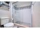 Bathroom featuring a tiled walk-in shower with glass doors, a new toilet, and a chrome overhead storage rack at 788 E Michigan St # 18, Orlando, FL 32806