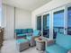 Relaxing balcony features stylish wicker furniture with vibrant cushions and ocean views through sliding glass doors at 807 S Atlantic Ave # 302, New Smyrna Beach, FL 32169