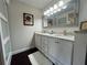 Elegant bathroom featuring a double vanity with white cabinets, granite counters, and a large framed mirror at 1312 2Nd St, Edgewater, FL 32132