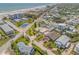 Aerial view of a coastal community with beach access and a tennis court. Several homes have private pools at 327 Due East St, New Smyrna Beach, FL 32169