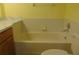 Yellow bathroom features a bathtub with tiled wall, vanity, and toilet at 714 Fox Tail Ct, New Smyrna Beach, FL 32168
