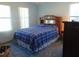 Comfortable bedroom featuring a blue plaid comforter and wood headboard with mirror accents at 714 Fox Tail Ct, New Smyrna Beach, FL 32168