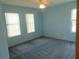 A serene, brightly-lit bedroom with three large windows, plush carpeting, and a ceiling fan at 714 Fox Tail Ct, New Smyrna Beach, FL 32168
