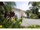 Two-car garage and landscaped entry with flowering plants at 2290 Hawks Cove Cir, New Smyrna Beach, FL 32168