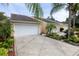 Tan stucco building with white garages and tropical landscaping at 2290 Hawks Cove Cir, New Smyrna Beach, FL 32168