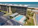 Aerial view of the condo complex showcasing a refreshing pool area near the ocean at 3180 Ocean Shore Blvd # 208, Ormond Beach, FL 32176