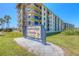 Seabridge North Condo building with lush landscaping, palm trees and a beautiful sign at 3180 Ocean Shore Blvd # 208, Ormond Beach, FL 32176
